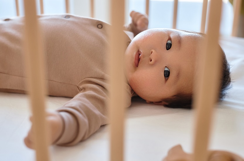 Newborn lying on his bed at home